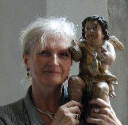 Fotografia przedstawiająca Teresą Rodzińską-Choroży trzymającą figurkę aniołka